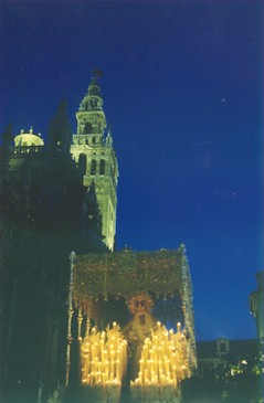 Wiele procesji wyrusza w Wielki Piątek o północy. W tle widać katedrę w Sewilli